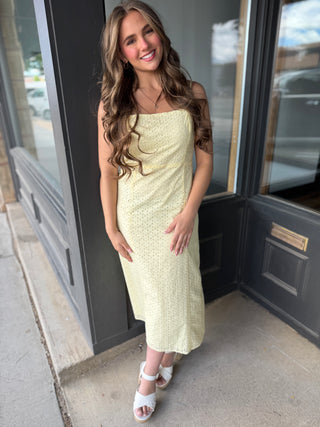 Woman in a light green dress standing outside a building