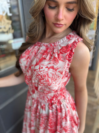 Woman wearing a red and white floral dress in an indoor setting