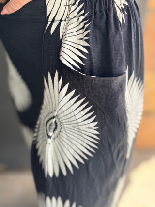 Black pants with white floral patterns on a blurred background