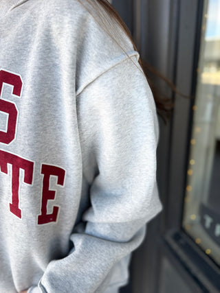 Gray sweatshirt with red text on a blurred background