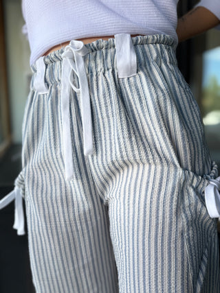 Striped pants with drawstring waistband worn by a person.