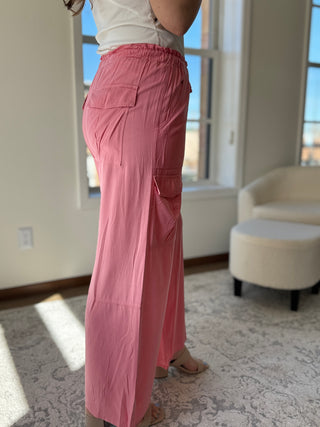 Lady wearing high waisted pink pant with elastic tie waistband and cargo pockets.
