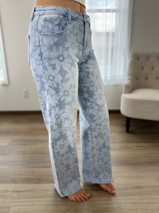 Light blue floral-patterned jeans worn by a person indoors.