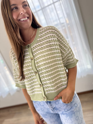 Woman wearing a green and white striped sweater indoors