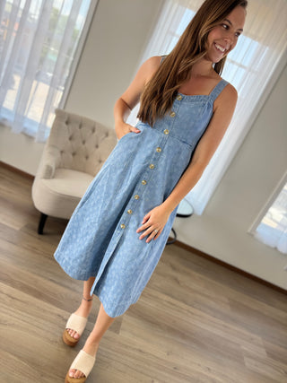Lady standing wearing a floral denim midi dress.