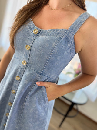 Lady standing wearing a floral denim midi dress.