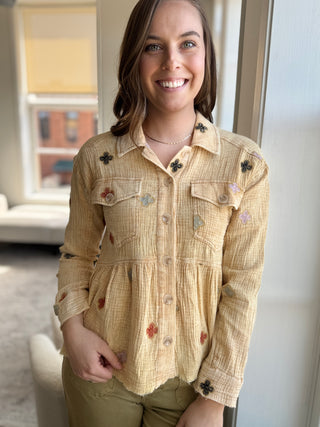 Photo of a woman wearing a washed yellow jacket with flower details.