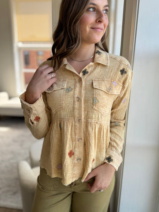 Photo of a woman wearing a washed yellow jacket with flower details.