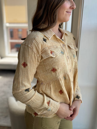 Photo of a woman wearing a washed yellow jacket with flower details.