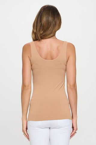 Woman wearing a beige tank top on a white background