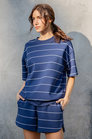 Woman wearing a blue striped outfit against a gray background