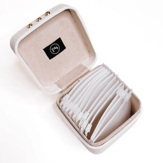 Open beige jewelry box with white jewelry inside on a white background